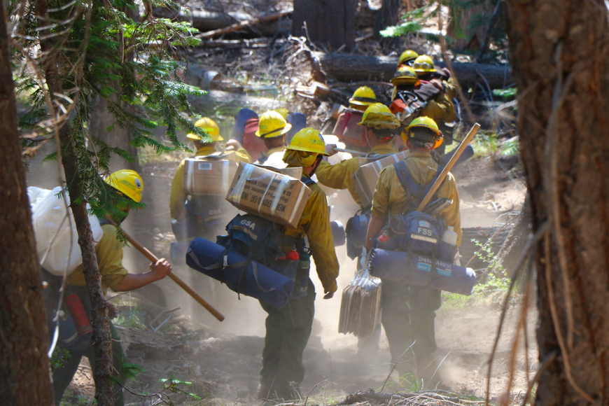 Firefighters working on a fire with a little bit of smoke in the air