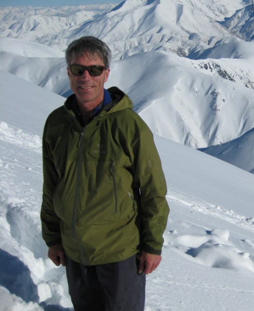 Karl Birkeland stands in front of a snowy mountain range.