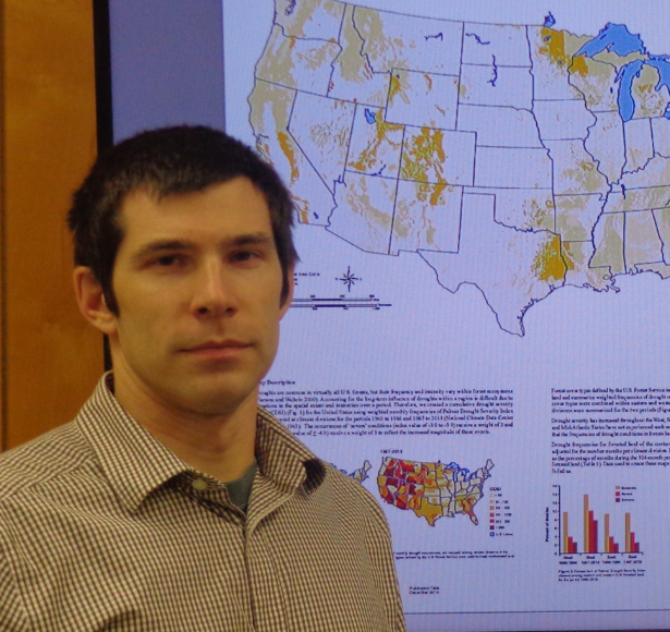 Matt Peters stands in front of his research poster.