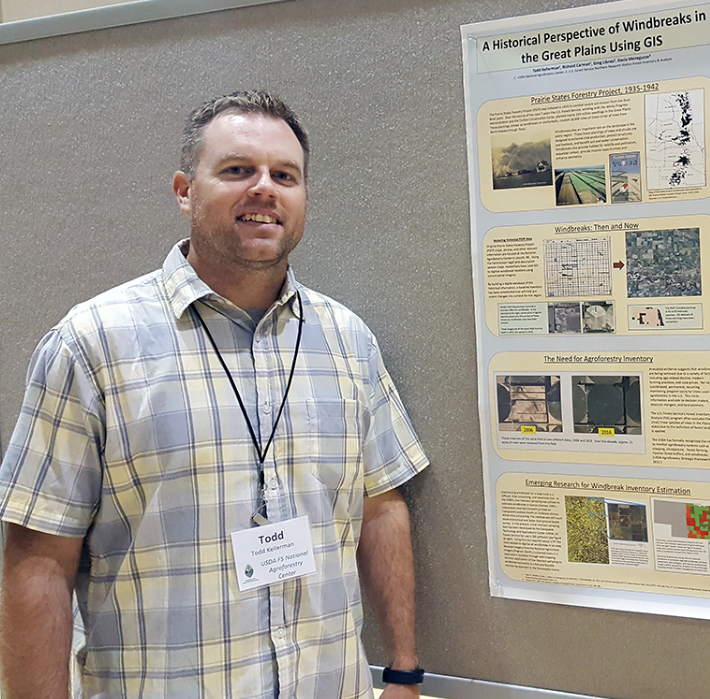 Todd Kellerman stands in front of his research poster.