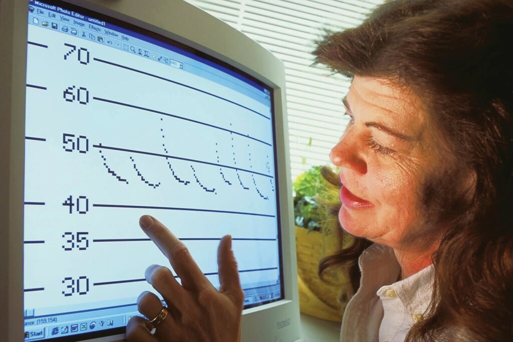 Sybill Amelon points to a computer screen with data displayed on it.