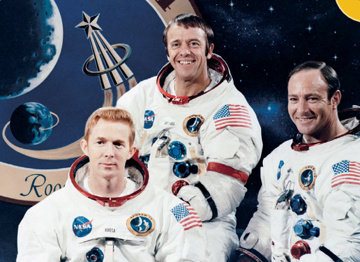 The three crew members of Apollo 14 wearing their space suits in front of the mission logo.