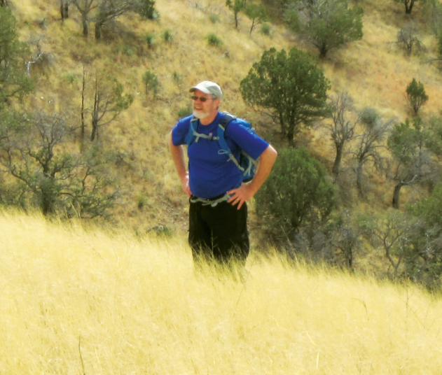 Joe Ganey stands on a grassy hillside.