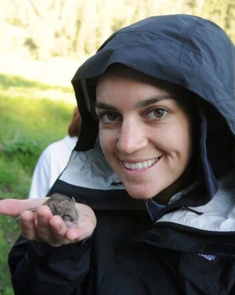 Serra Hoagland wears a hooded jacket and holds a mouse.