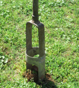 A core sampling tool digs into the soil to take a sample.