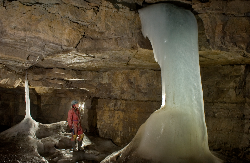 A woman studying a formation in a cave