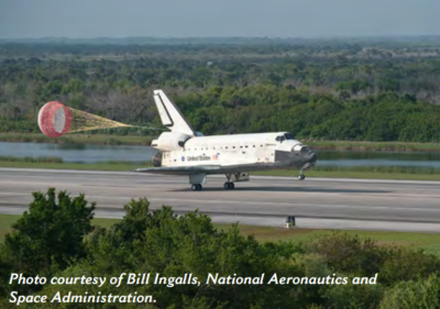 A plane with a parachute in the back on a runway
