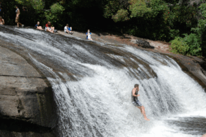People kayaking off of a small waterfall
