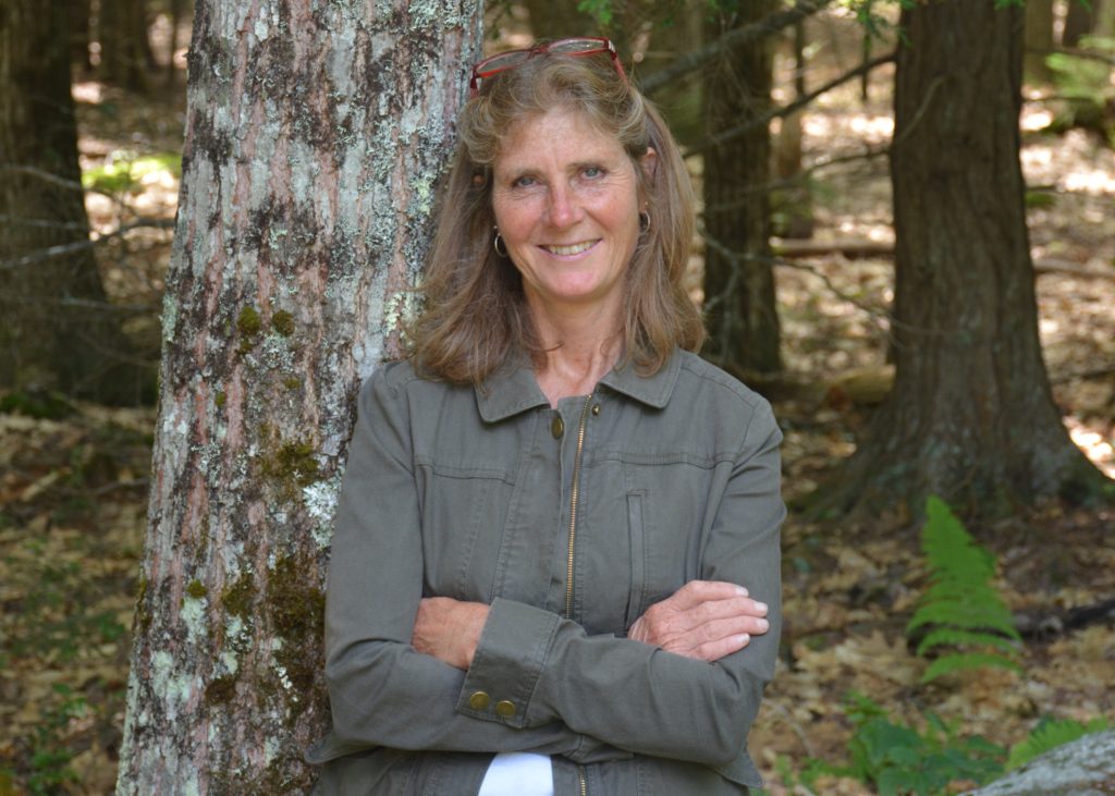 Lindsey Rustad leaning on a tree outside