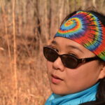 Rima Lucardi with sunglasses and a tie dye headband