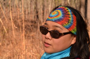 Rima Lucardi with sunglasses and a tie dye headband