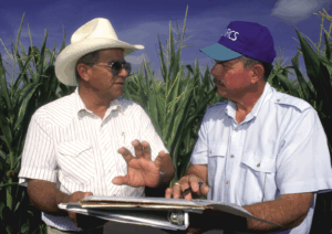 A federal worker and farmer having a discussion in a field