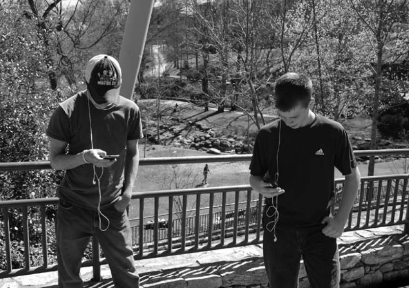 Two boys outside using ipods