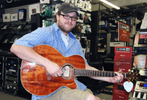 A man playing a Koa guitar