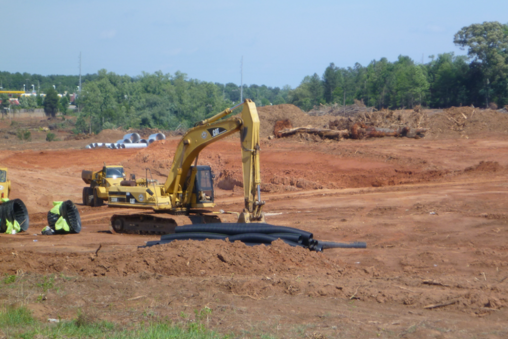 An area that is under construction. There is a bulldozer in a pit of dirt