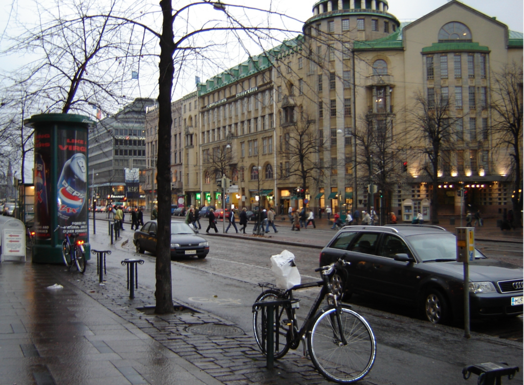 A city street with cars and bikes