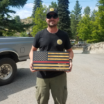 Picture of Brian Campbell outside holding a wooden American flag