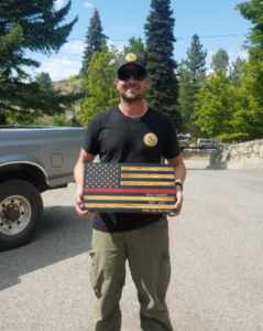 Picture of Brian Campbell outside holding a wooden American flag
