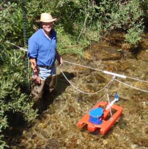 Charles Luce standing in water with a measurement tool