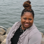 Dr. Moore sits beside a body of water