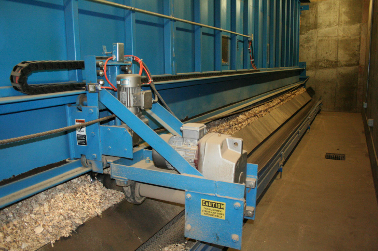 wood chips on a conveyer belt with other equpiment