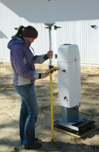 Christie Hawley using a scientific device to measure something in the ground
