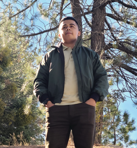 Mr. Pacheco stands outside in a forest