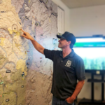 Mr. Walther stands and points at a location on a map on the wall