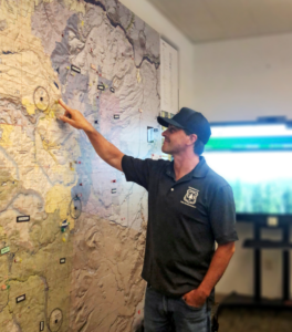 Mr. Walther stands and points at a location on a map on the wall