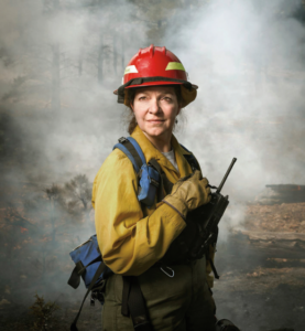 Dr. Lata stands in a smoky forest in full gear