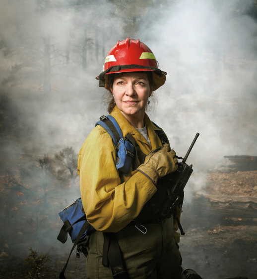 Dr. Lata stands in a smoky forest in full gear