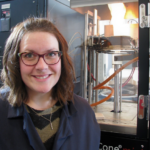 Dr. Hasburgh stands in front of lab equipment