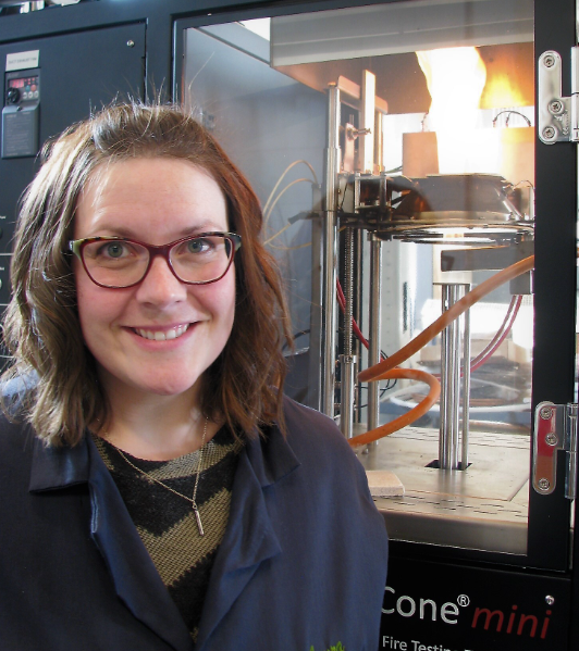 Dr. Hasburgh stands in front of lab equipment