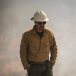 Jacob Gear in uniform walking through a smokey area
