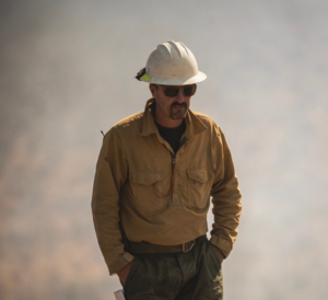 Jacob Gear in uniform walking through a smokey area
