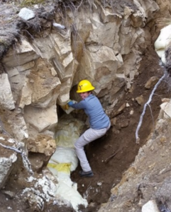 Jenna Padilla climbing rocks in a hard hat