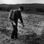 Keith Arnold with a backpack tool on his back in the forest