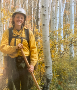 Portrait of Milena Rockwood in uniform holding a shovel in the forest