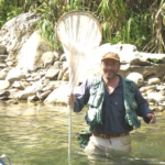 Nathan Schiff Standing in a body of water holding up a net