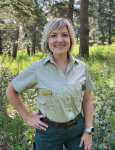 Ms. Dunn stands outside in her Forest Service uniform