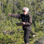 Robert DeVelice working in a forested area