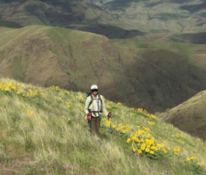 Upekala Wijayratne hiking a grassy mountain arera