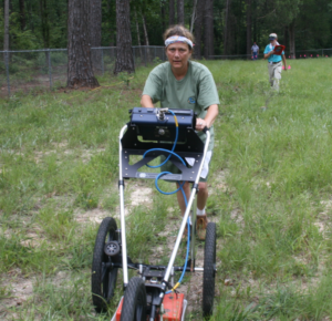 Velicia Berstrom pushing a instrument through a grassy area