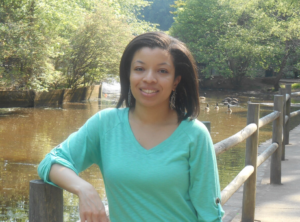 Portrait of Viniece outside leaning against a fence