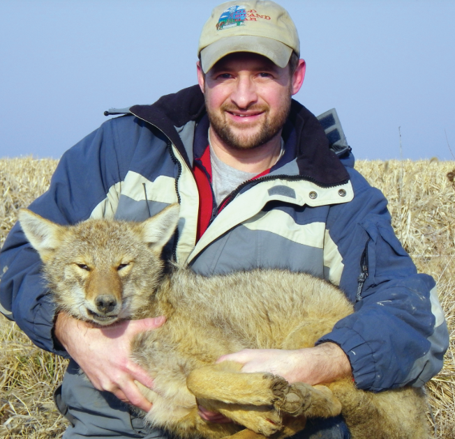 Dr. Lesmeister holds a coyote