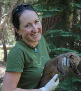 Dr. Moriarty wears gloves and holds a marten