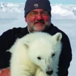 Dr. Marcot holds a young polar bear.