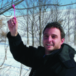 Dr. Widenhoeft holds a tag on a tree branch