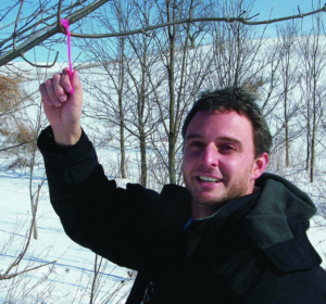Dr. Widenhoeft holds a tag on a tree branch