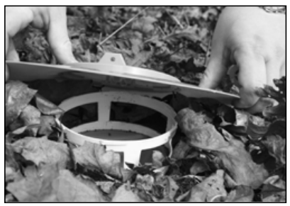 A person placing a lid over the trap